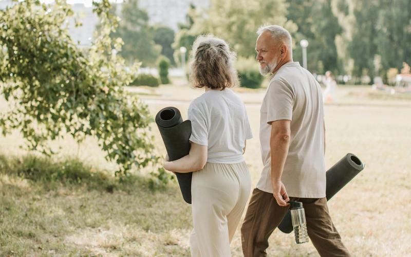 a man and woman walking with yoga mats